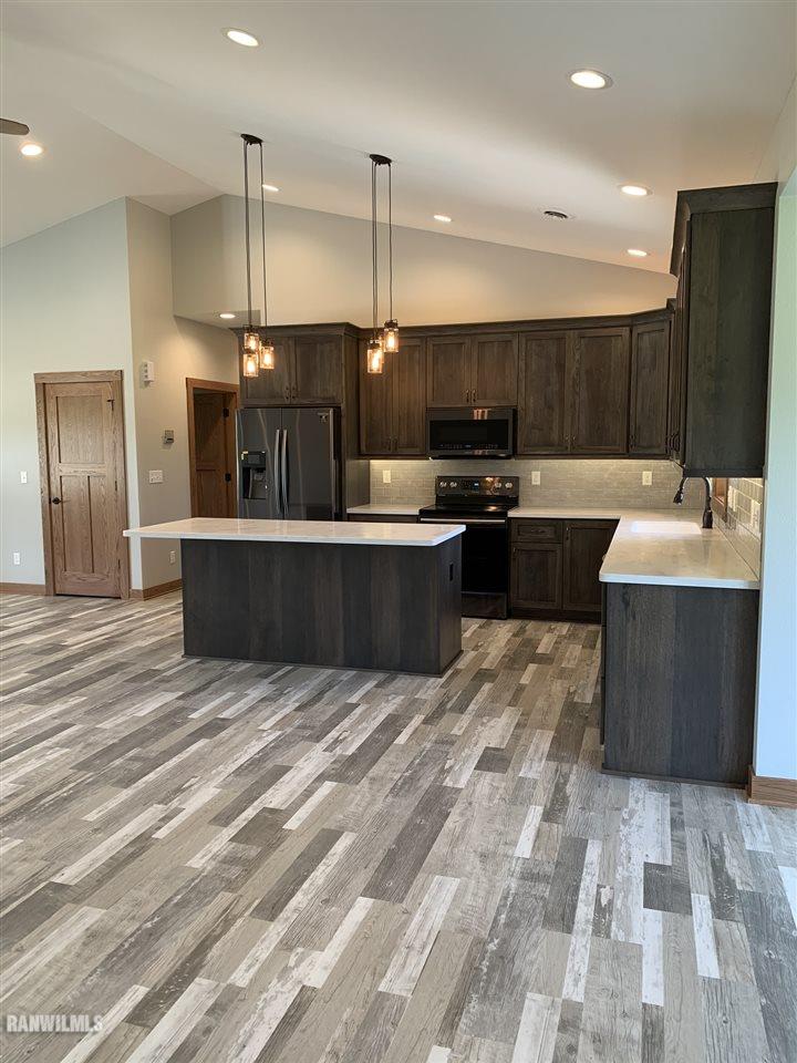 407 Oak Ridge Drive Lena, IL 61048 - Photo 11 of 50 a large kitchen with kitchen island a sink stainless steel appliances and cabinets