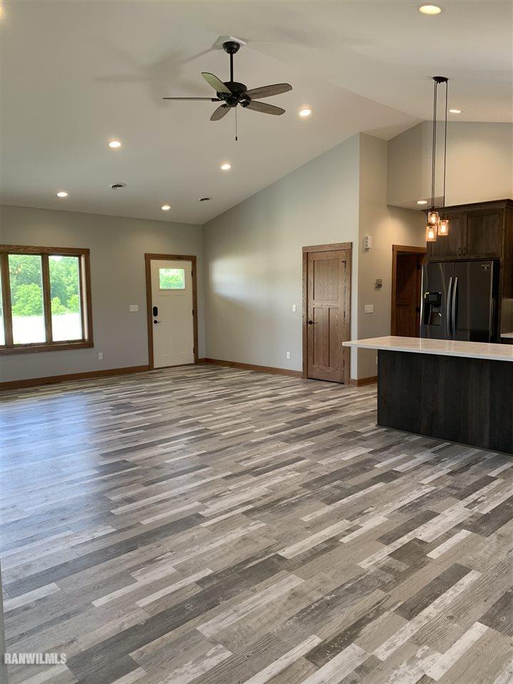 407 Oak Ridge Drive Lena, IL 61048 - Photo 12 of 50 an empty room with wooden floor and a hallway