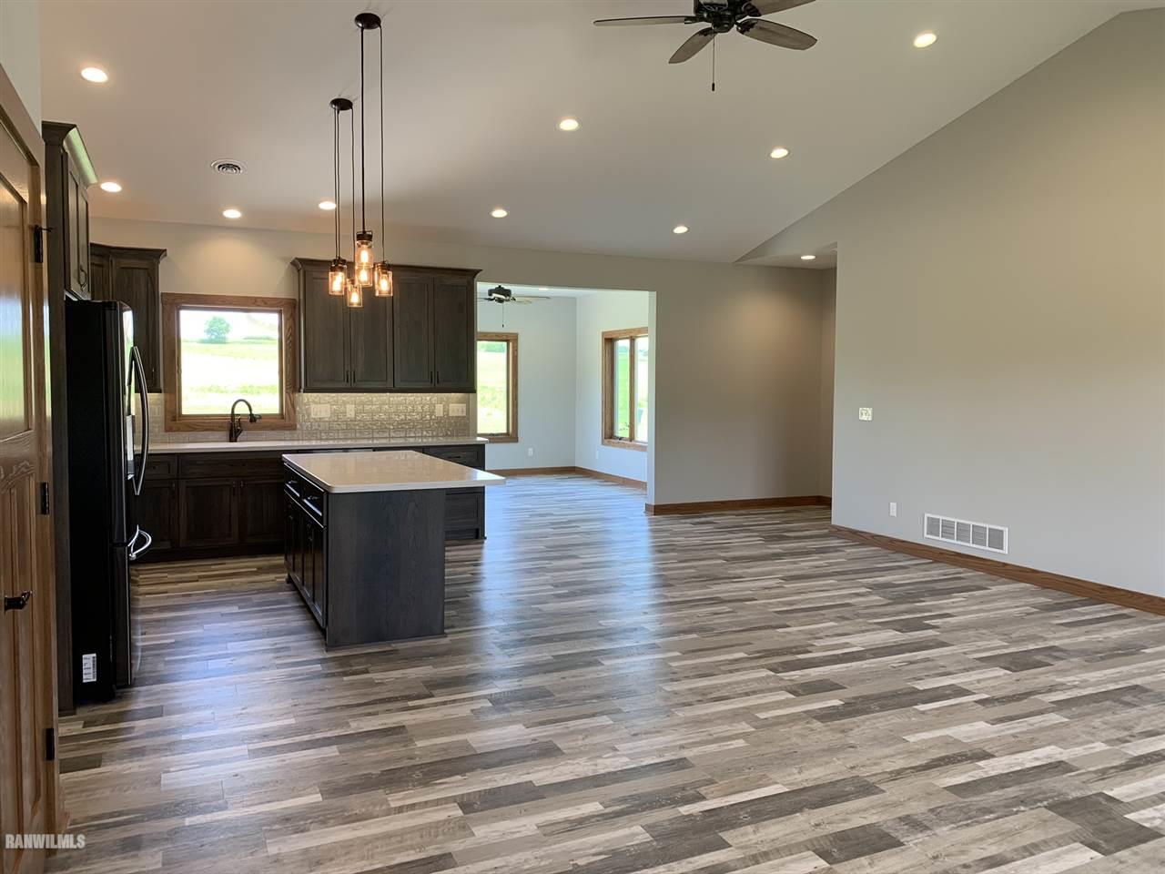 407 Oak Ridge Drive Lena, IL 61048 - Photo 15 of 50 a large kitchen with granite countertop a large counter top stainless steel appliances and wooden floor