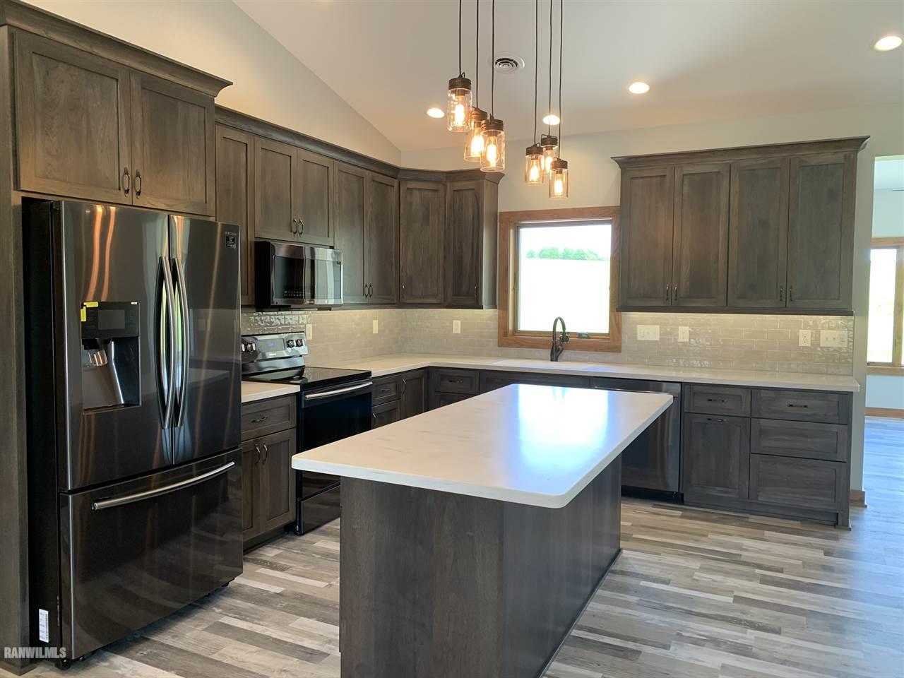 407 Oak Ridge Drive Lena, IL 61048 - Photo 19 of 50 a kitchen with kitchen island granite countertop stainless steel appliances a sink stove refrigerator and cabinets