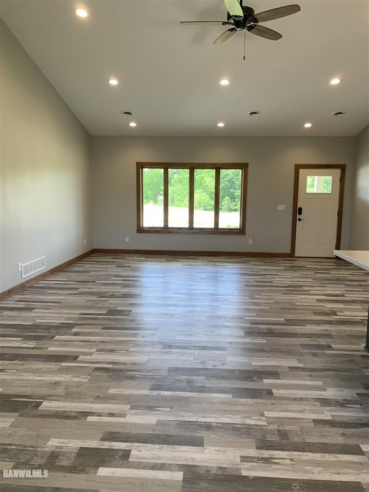 407 Oak Ridge Drive Lena, IL 61048 - Photo 9 of 50 an empty room with wooden floor and windows