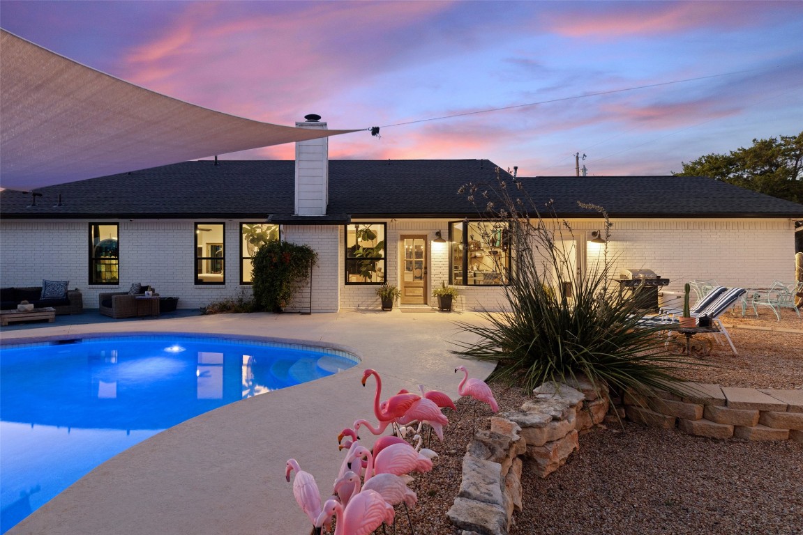 120 Oak Springs Drive Dripping Springs, TX 78620 - Photo 2 of 35 a swimming pool with outdoor seating and yard in back