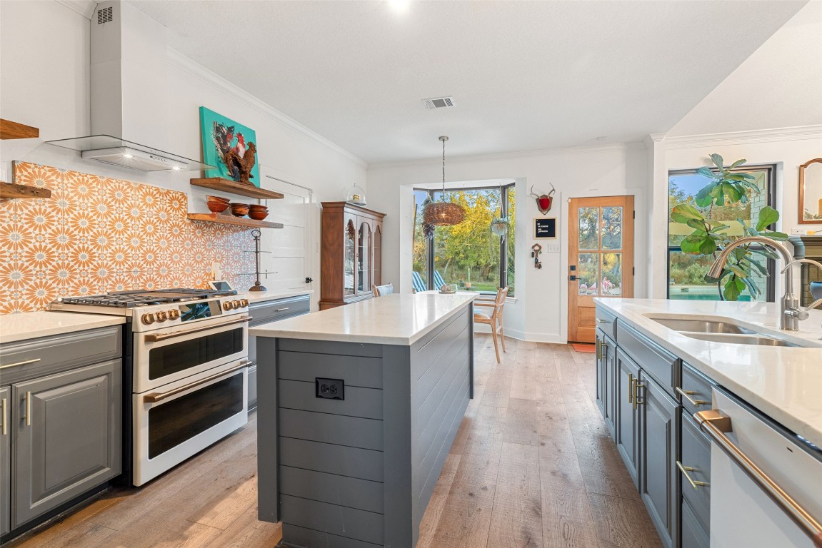 120 Oak Springs Drive Dripping Springs, TX 78620 - Photo 24 of 35 a kitchen with stainless steel appliances granite countertop a stove and a wooden floors