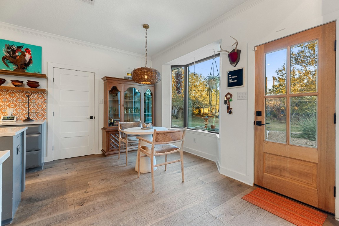 120 Oak Springs Drive Dripping Springs, TX 78620 - Photo 26 of 35 Dining area featuring light wood finished floors and ornamental molding