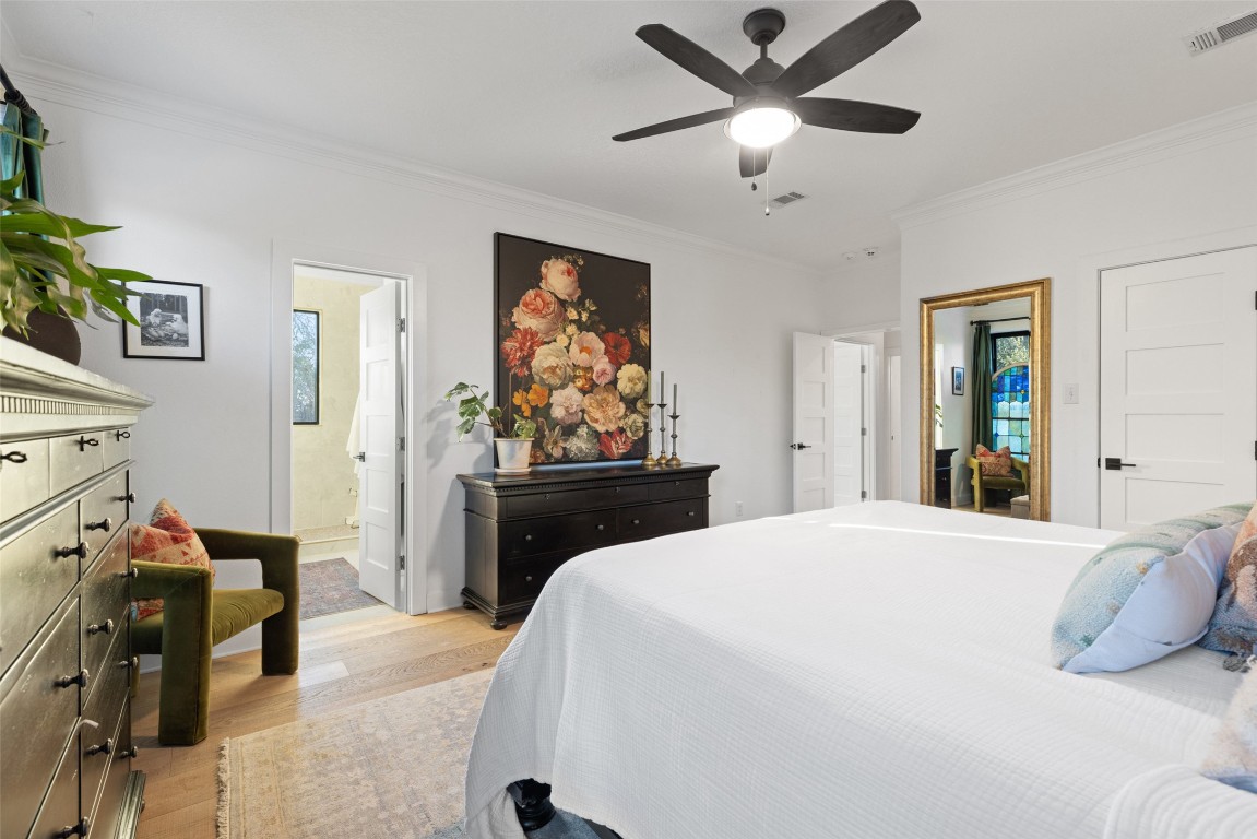 120 Oak Springs Drive Dripping Springs, TX 78620 - Photo 8 of 35 Bedroom featuring crown molding, light wood finished floors, a ceiling fan, and ensuite bathroom