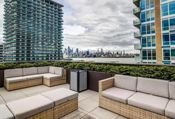 a view of a roof deck with couches and potted plants