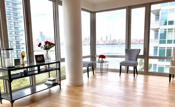 a dining room with wooden floor windows and glass view