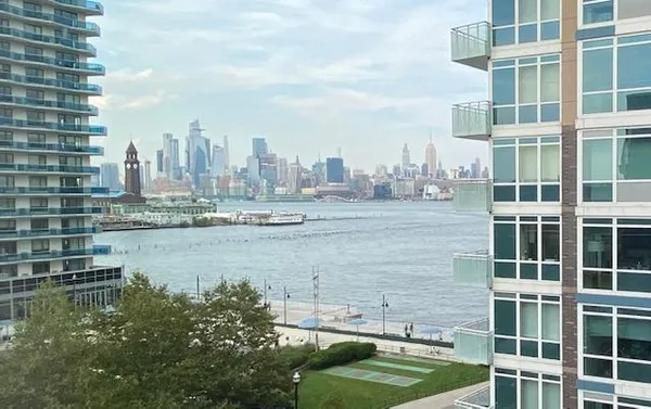 a view of a lake with building and trees in front of it