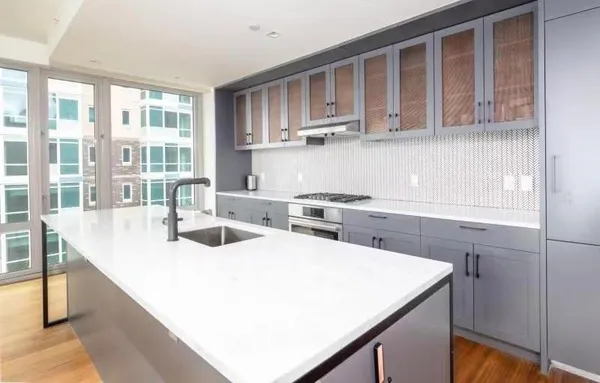 a kitchen with kitchen island a stove a sink and cabinets