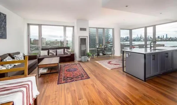 a living room with furniture and a large window with wooden floor
