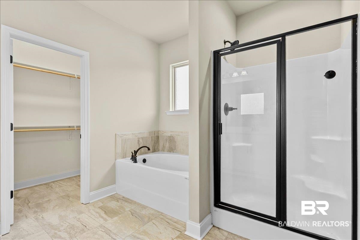 1112 Stella Road Foley, AL 36535 - Photo 15 of 33 Bathroom featuring a stall shower, a garden tub, and a walk in closet