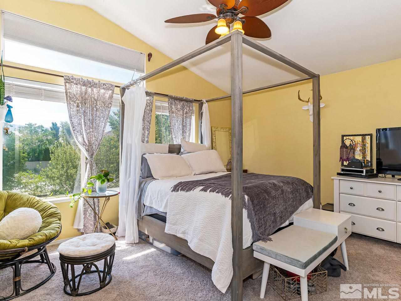 9799 Northrup Drive Reno, NV 89521 - Photo 11 of 16 a bedroom with a bed and a chandelier