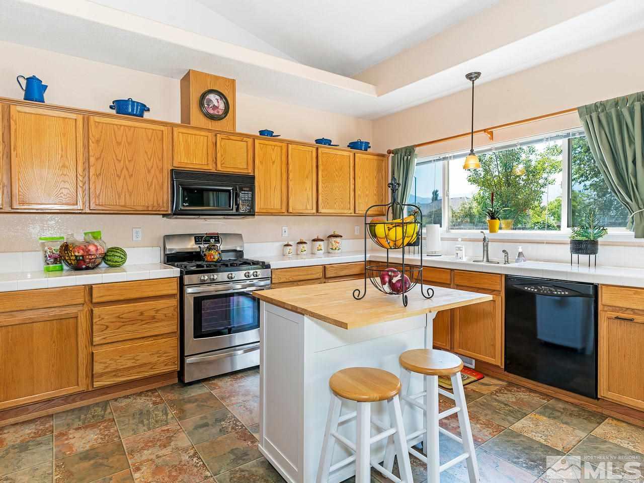 9799 Northrup Drive Reno, NV 89521 - Photo 3 of 16 a kitchen with stainless steel appliances granite countertop a sink stove and refrigerator
