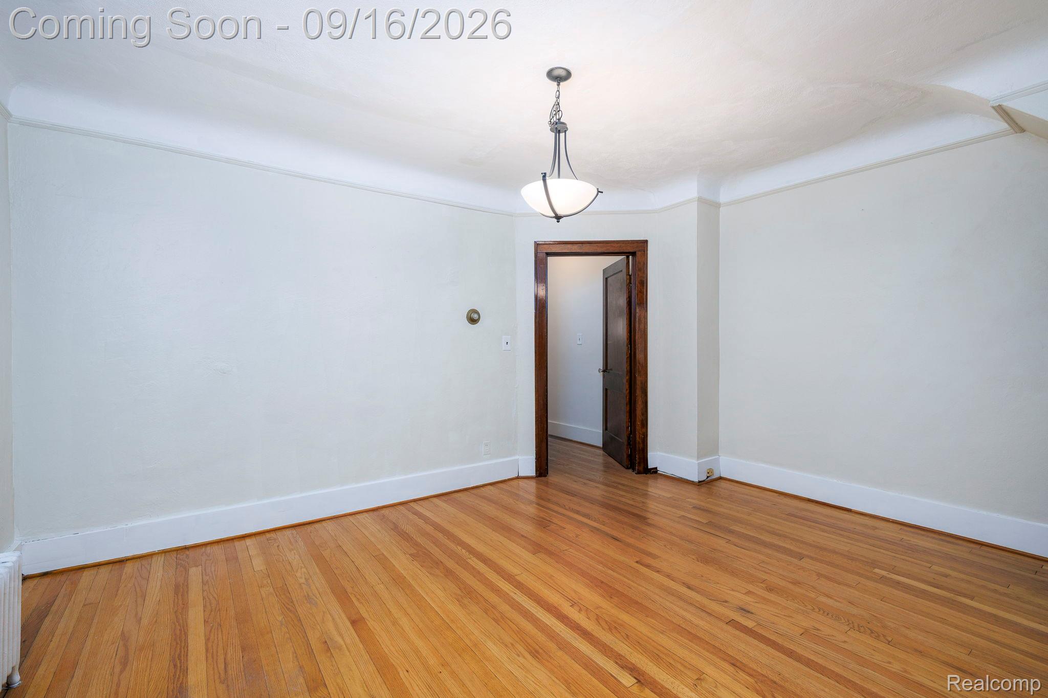 999 Nottingham Road Grosse Pointe, MI 48230 - Photo 13 of 30 Hardwood flooring, painted walls, crown molding, and a ceiling-mounted light fixture