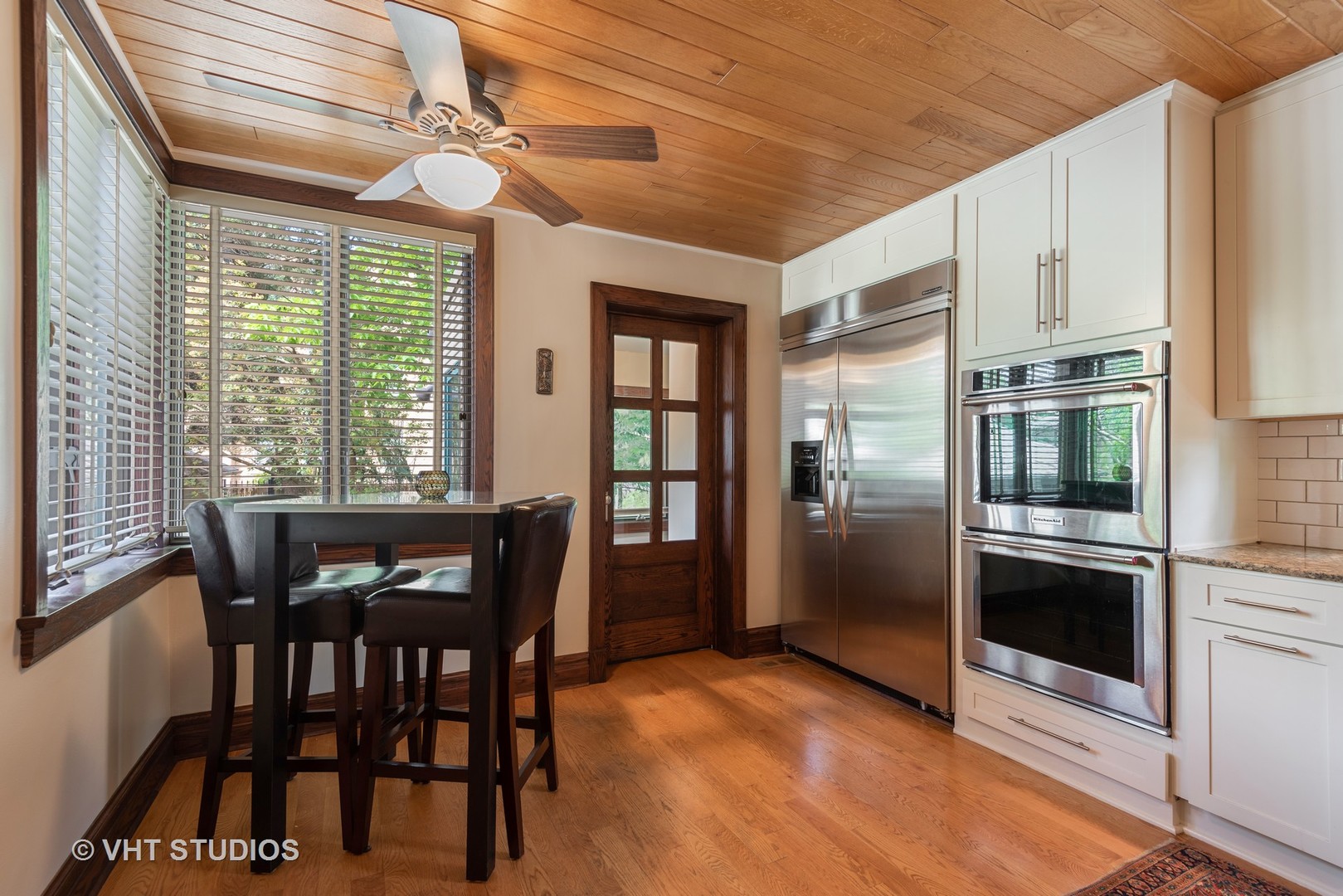 7406 North Sheridan Road Chicago, IL 60626 - Photo 12 of 37 a kitchen with stainless steel appliances wooden floor dining table and chairs