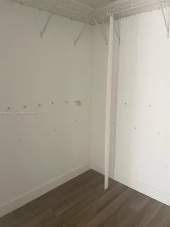 an empty room with wooden floor and closet