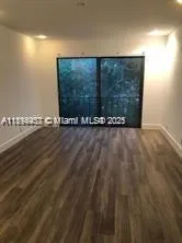 a view of an empty room with a wooden floor and a bench