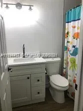 a bathroom with a granite countertop toilet sink and mirror