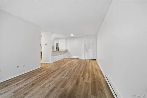 a view of empty room with wooden floor