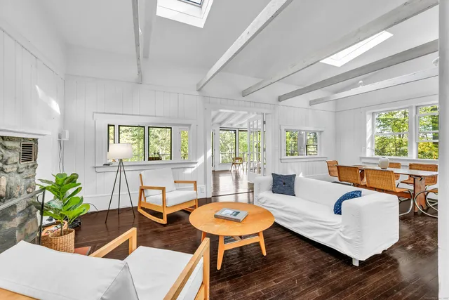 a living room with furniture a large window and wooden floor