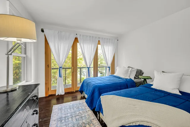 a bedroom with two beds and a large window