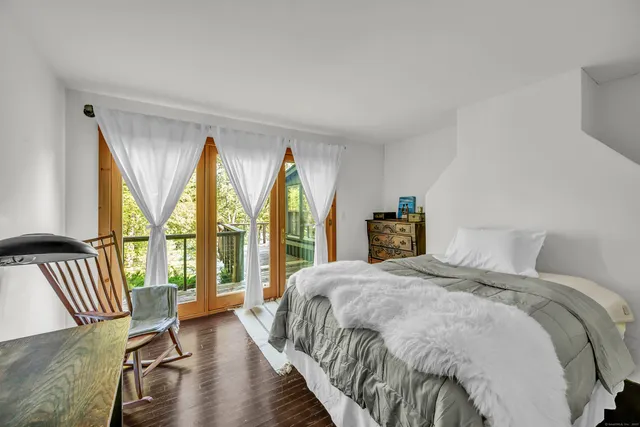 a bedroom with a bed and a large window