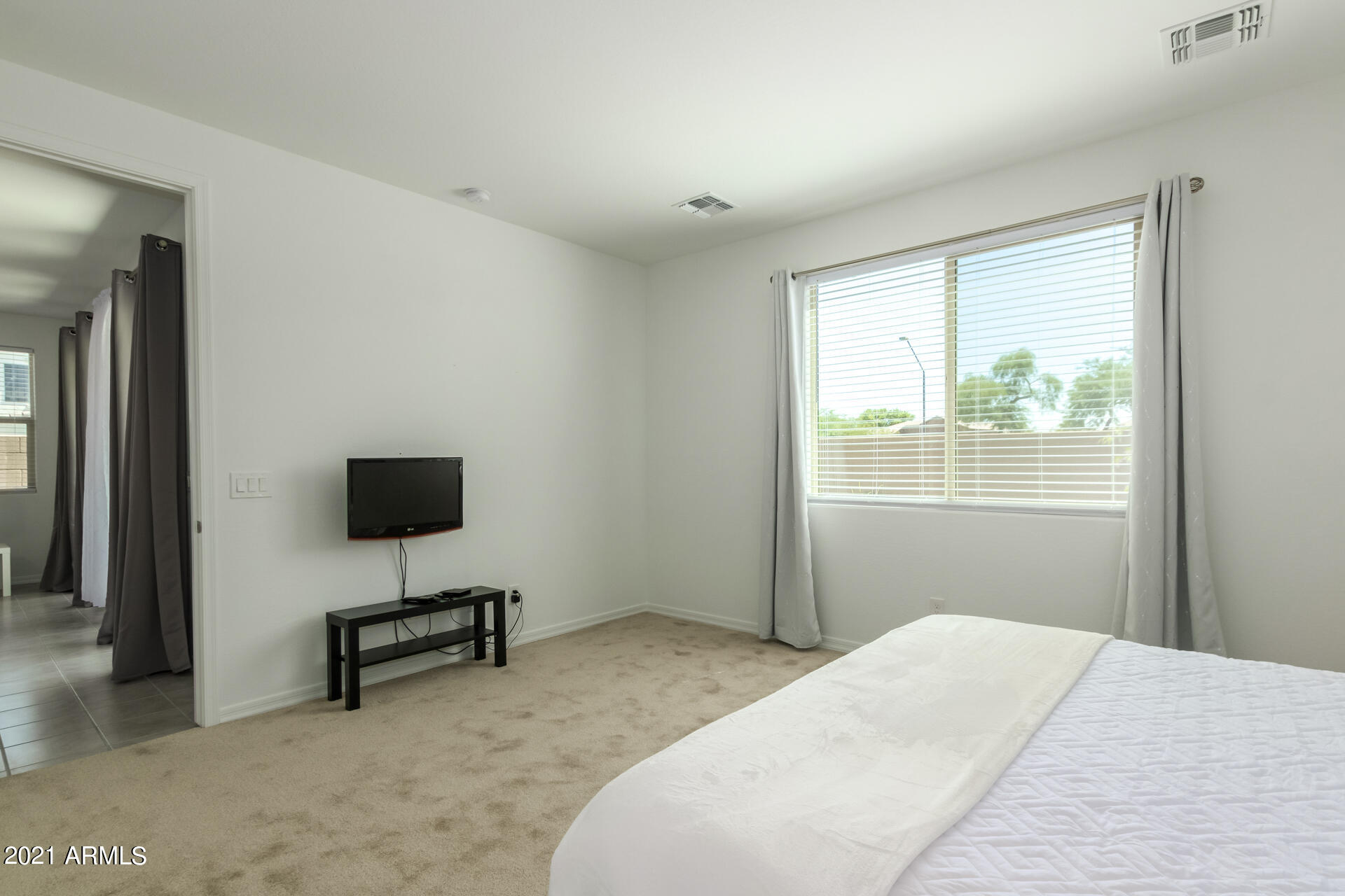 1507 South Honeysuckle Lane Gilbert, AZ 85296 - Photo 19 of 32 a bedroom with a bed a lamp and a window