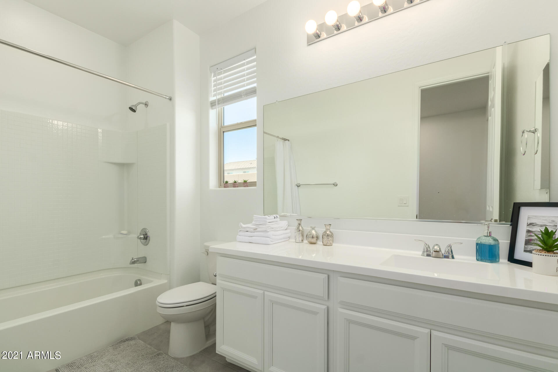 1507 South Honeysuckle Lane Gilbert, AZ 85296 - Photo 22 of 32 a bathroom with a double vanity sink toilet a large mirror a shower and bathtub