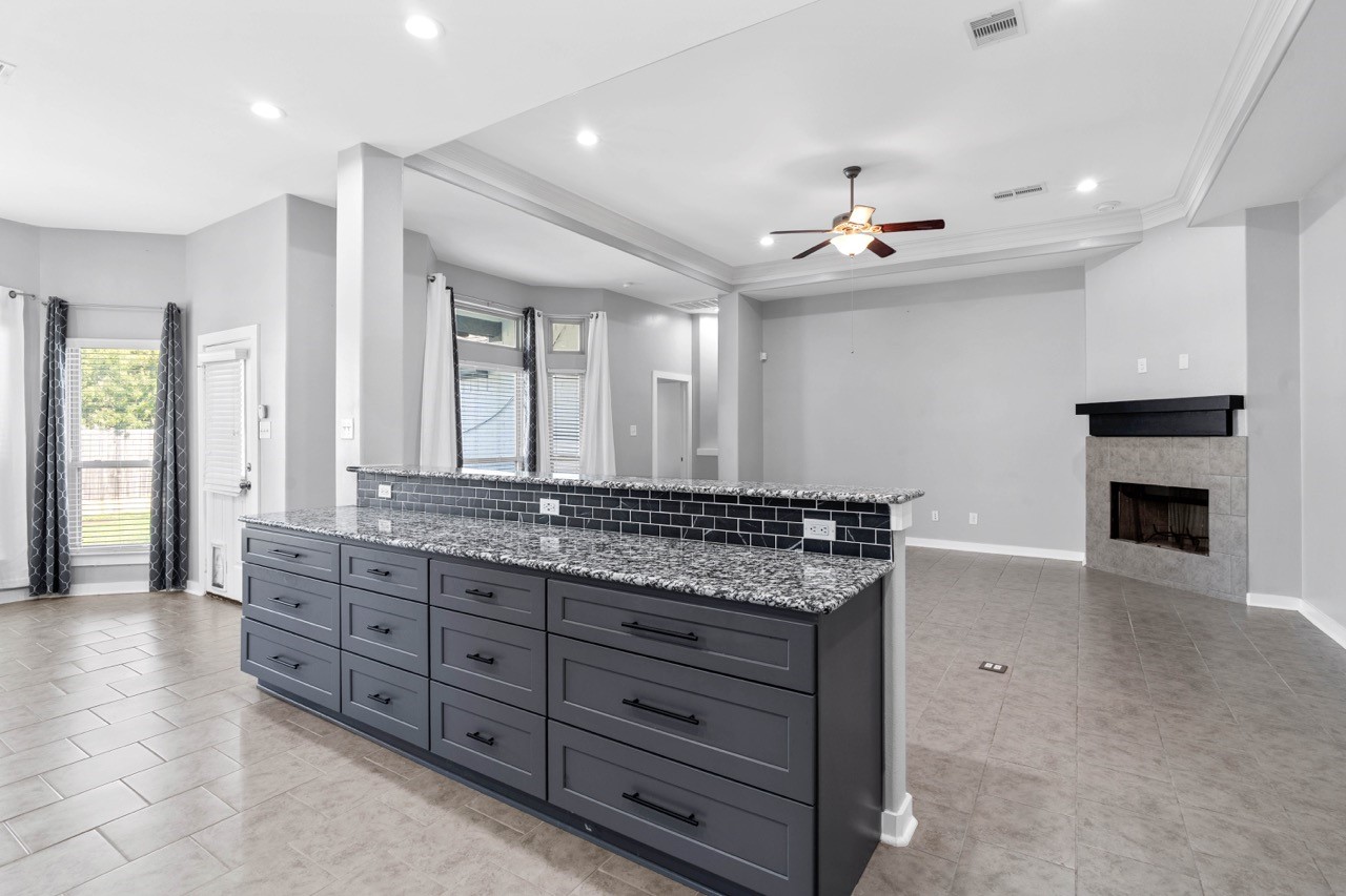 12126 Walden Road Montgomery, TX 77356 - Photo 26 of 50 This spacious open-concept layout is perfect for entertaining, featuring a brand-new kitchen bar with stunning granite countertops and abundant storage. The extended bar overlooks the living and dining areas, creating a seamless flow for gatherings and everyday living. Multiple conveniently placed outlets along the bar make it ideal for small appliances, charging stations, or buffet-style serving. With wide, open sightlines and plenty of room to host, this space is designed for both functionality and fun.