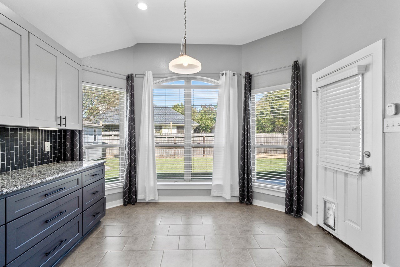 12126 Walden Road Montgomery, TX 77356 - Photo 28 of 50 Bright and inviting dining area featuring a beautiful bay-style window that fills the space with natural light and offers peaceful views of the backyard. The large windows create an open, airy feel—perfect for morning coffee, casual meals, or a cozy reading spot. A charming highlight that enhances both the style and comfort of the home. Door leads to the back patio.