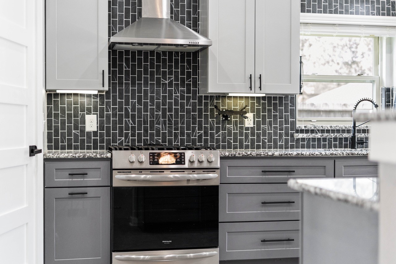 12126 Walden Road Montgomery, TX 77356 - Photo 33 of 50 This kitchen is a cook’s dream, featuring a brand-new stainless-steel gas stove paired with a sleek new vent hood that’s ready for everything from quick weekday meals to your most impressive dinner-party creations. The powerful burners and modern controls make cooking feel effortless, while the stylish hood keeps the space fresh as you sauté, sear, and serve. Surrounded by stunning tile backsplash and updated custom cabinetry, this setup brings both performance and personality to the heart of the home.