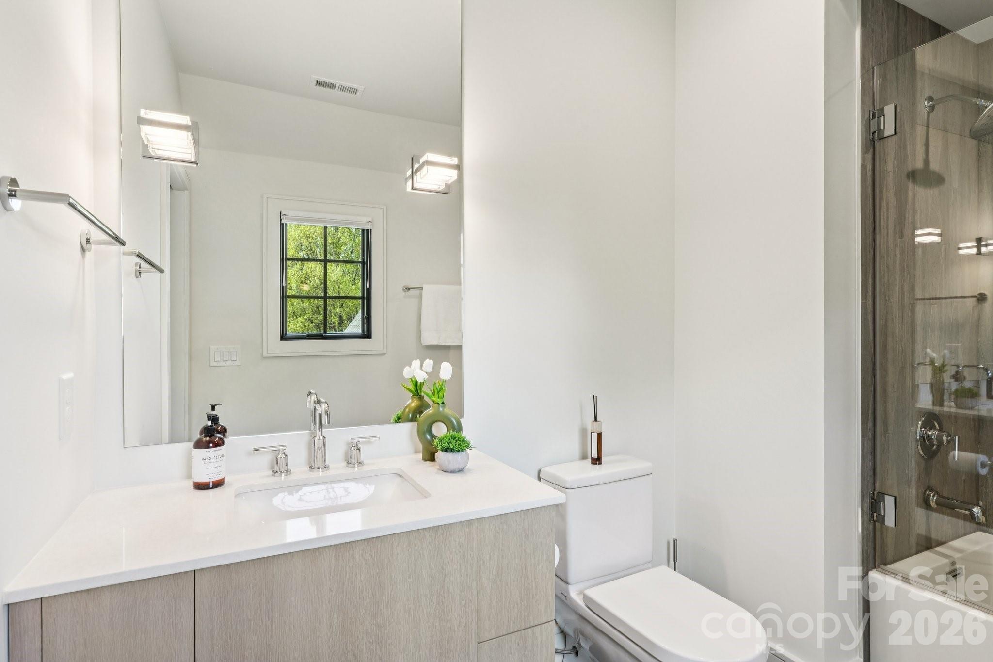 2103 Cortelyou Road Charlotte, NC 28211 - Photo 30 of 45 a bathroom with a granite countertop sink mirror vanity and toilet