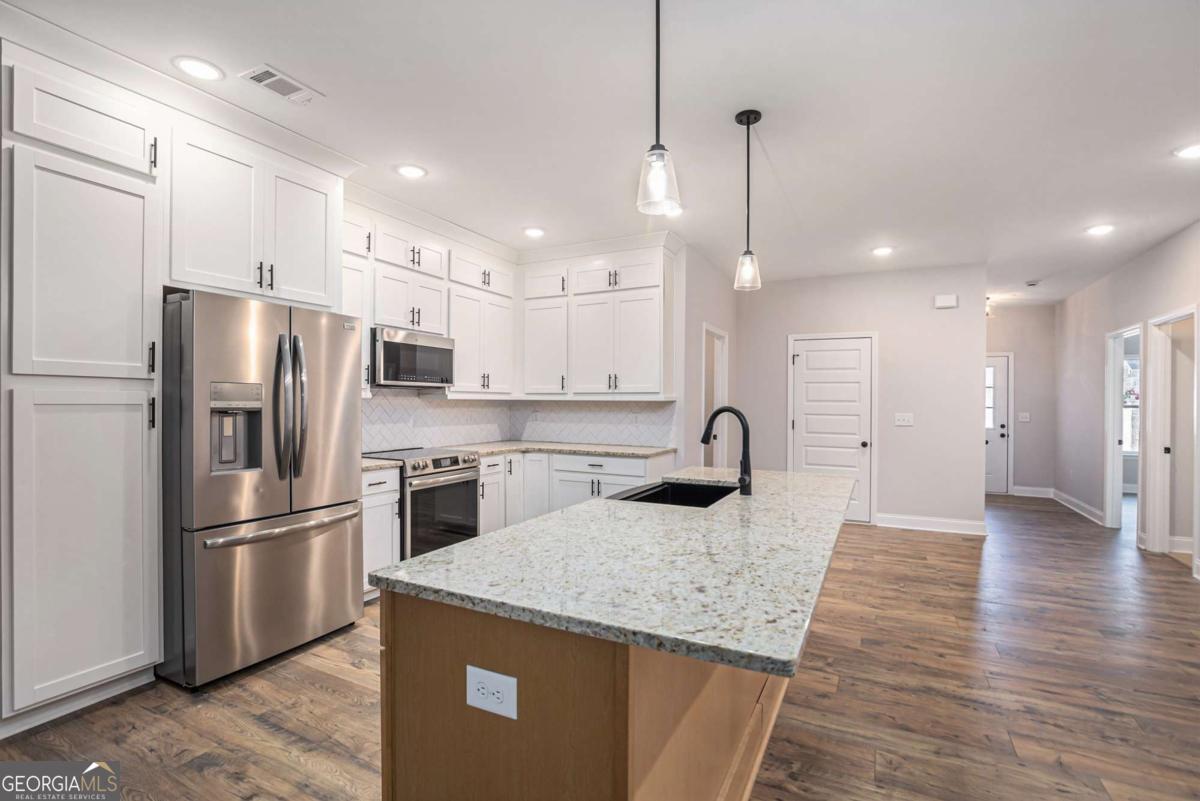 138 Crest Pointe Bremen, GA 30110 - Photo 12 of 24 a kitchen with stainless steel appliances granite countertop a refrigerator a sink dishwasher a stove and a refrigerator with wooden floor