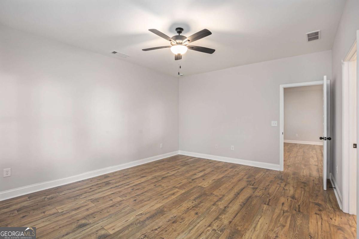 138 Crest Pointe Bremen, GA 30110 - Photo 17 of 24 an empty room with wooden floor and ceiling fan