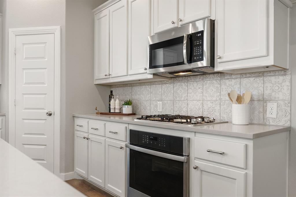 1908 Quail Lane Argyle, TX 76226 - Photo 11 of 30 a kitchen with stainless steel appliances granite countertop white cabinets a sink and dishwasher