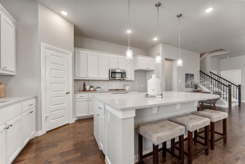 1908 Quail Lane Argyle, TX 76226 - Photo 4 of 30 a large kitchen with kitchen island a sink table and chairs
