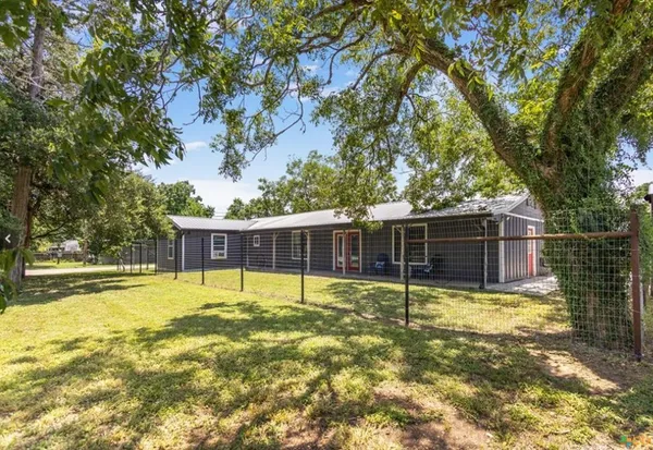 a view of a backyard with large tree