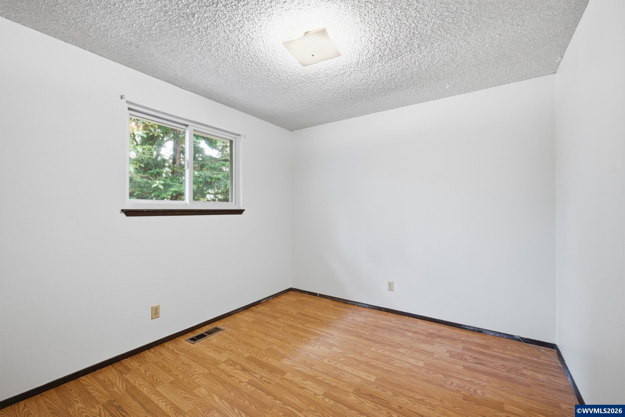 1213 Hemlock Loop Independence, OR 97351 - Photo 20 of 28 an empty room with wooden floor and windows