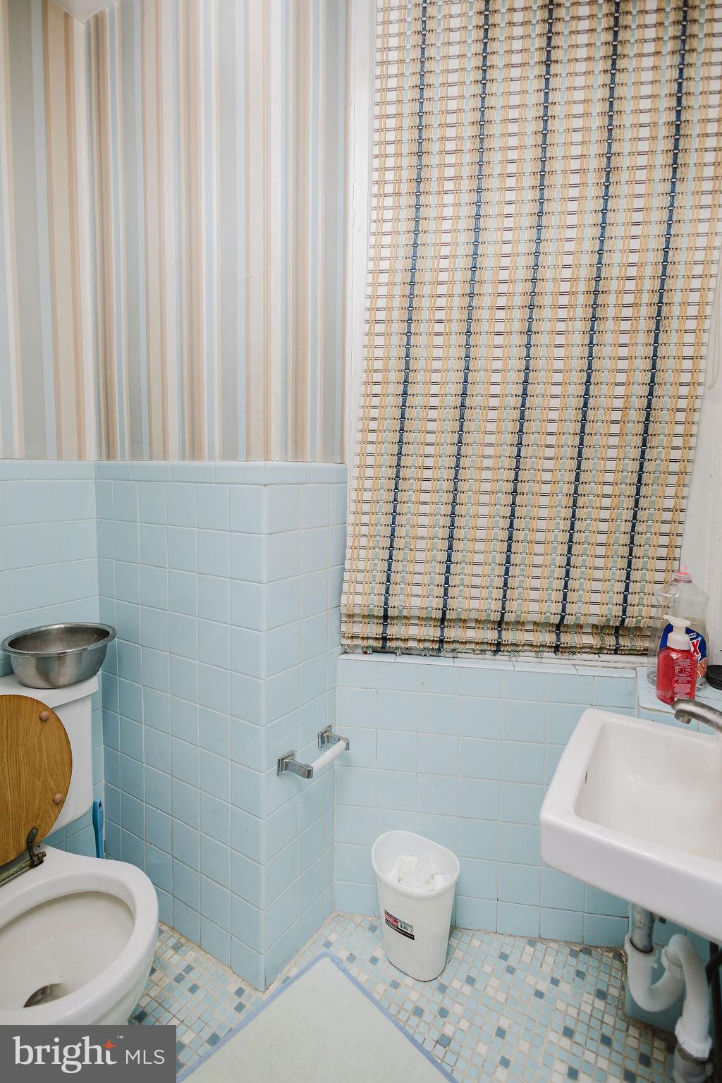 2318 South Broad Street Philadelphia, PA 19145 - Photo 12 of 28 a bathroom with a toilet a sink and a window