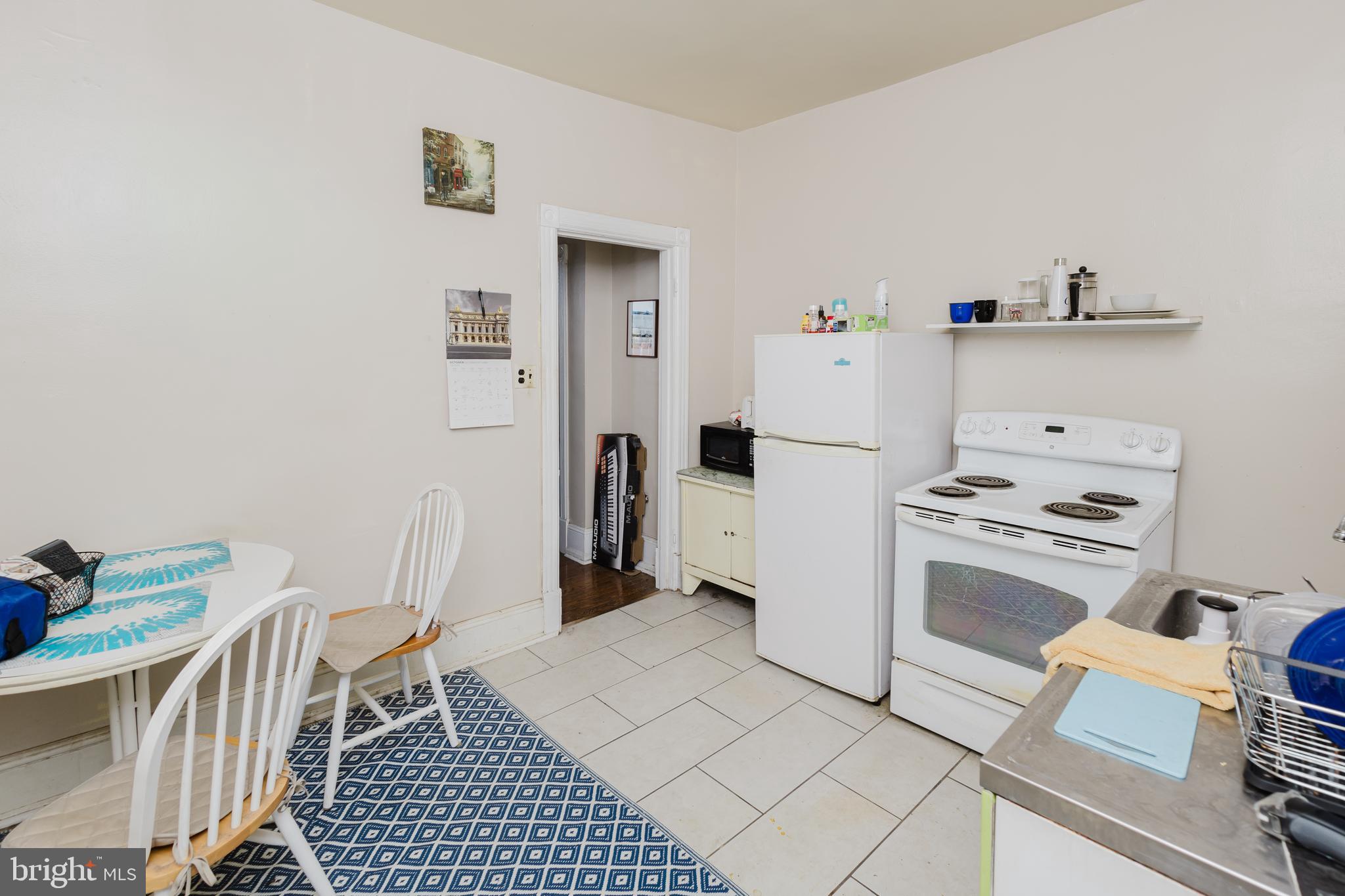 2318 South Broad Street Philadelphia, PA 19145 - Photo 24 of 28 a kitchen with a refrigerator a stove top oven and a counter space