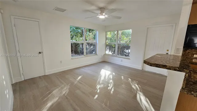 a view of a livingroom with wooden floor and a window