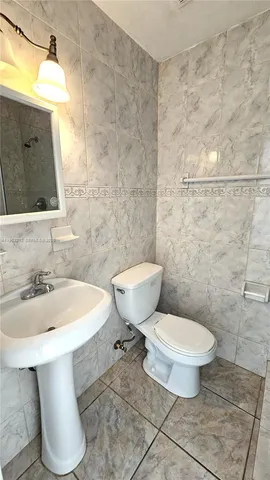 a bathroom with a sink a toilet and mirror