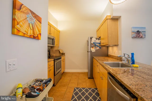 a bathroom with a granite countertop sink and a washing machine