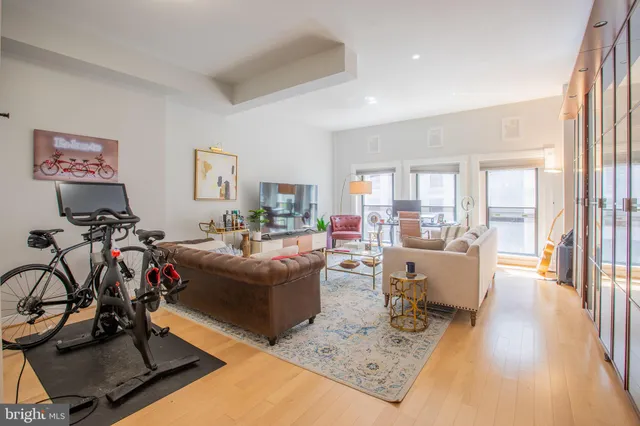 a living room with furniture a wooden floor and a large window