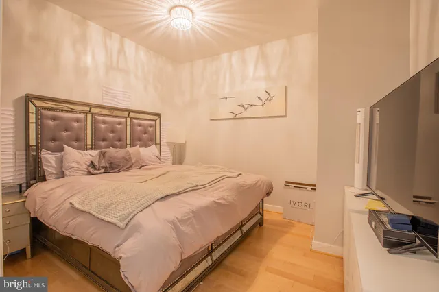 a bedroom with a large bed and a flat tv screen on a dresser