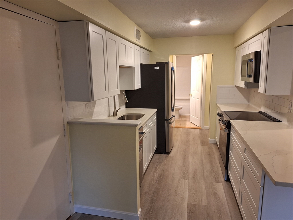 10 Beal's Cove Road, Unit C Hingham, MA 02043 - Photo 4 of 10 a kitchen with a sink stove and refrigerator