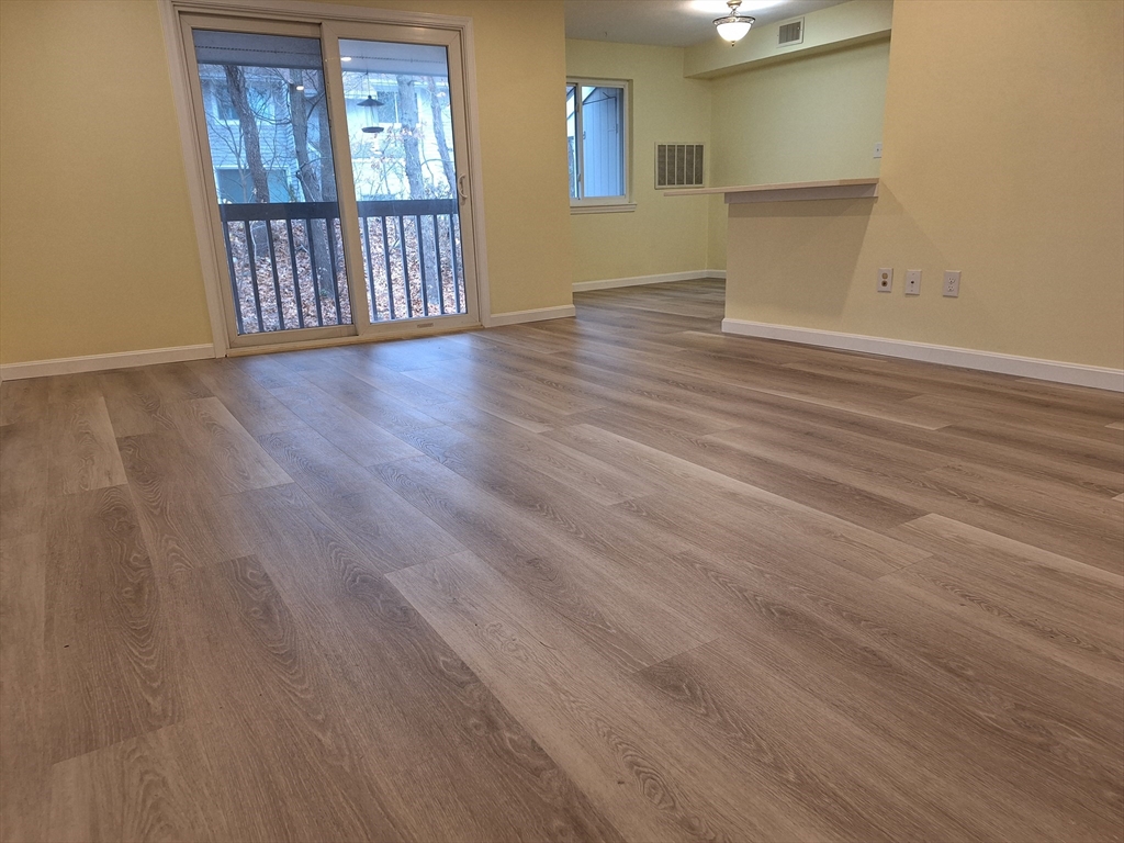 10 Beal's Cove Road, Unit C Hingham, MA 02043 - Photo 9 of 10 a view of an empty room with wooden floor and a window