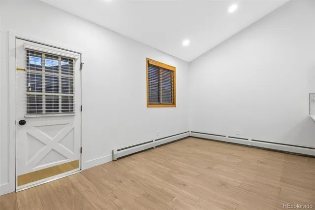 an empty room with wooden floor and windows