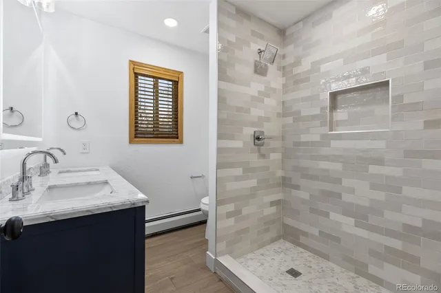 a bathroom with a sink shower and a mirror