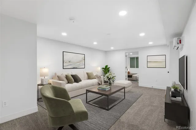 a living room with furniture a flat screen tv and a refrigerator